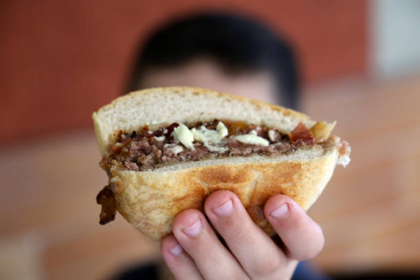 istock child's hand holding a burger in front of the camera 1329420816