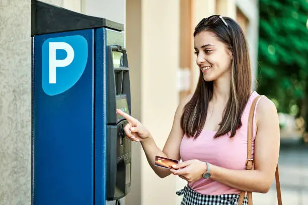 Photo of Young Woman Using Parking Machine