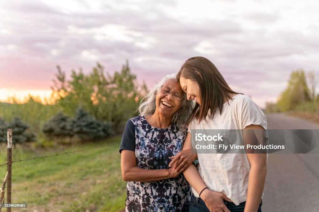 Ethnic Senior Mother Walking With Her Adult Daughter A beautiful senior mom of pacific island descent is walking outdoors with her adult thirty something year old daughter. They are enjoying each others company and soaking in the gorgeous, colorful, sunset. Senior Adult Stock Photo