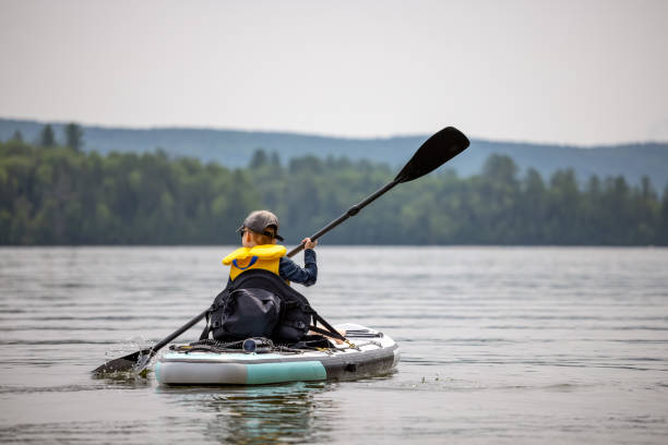 istock Little Redhead Boy Kayaking on Paddleboard during a warm sunny summer vacation day 1329432668