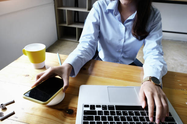 istock focus Female hand holding Smartphone to Charging at Wireless fast Charging pad at work. vintage tone. 1329434040