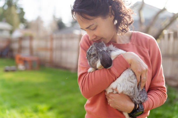 istock Ethnic Woman Snuggling Her Pet Bunny Outside 1329435518