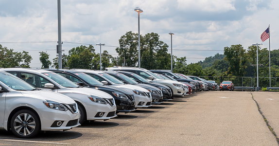 Wilkins Township, Pennsylvania, USA July 18, 2021 Brand new Nissan automobiles together in a parking lot at a dealership on a sunny summer day