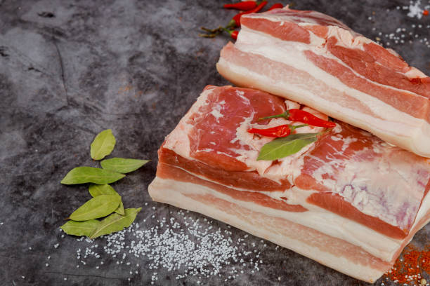 istock Boneless raw pork belly on dark background. 1329437122