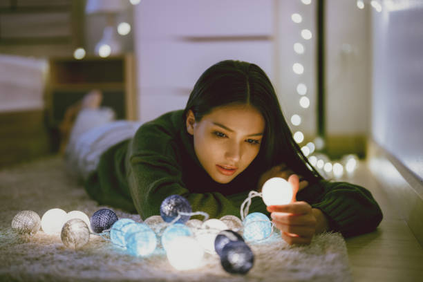 istock Asian woman stay home alone she is playing with lights 1329437832