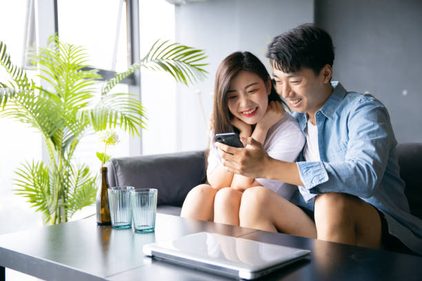 istock Happy young couple share information on mobile phone 1329442767