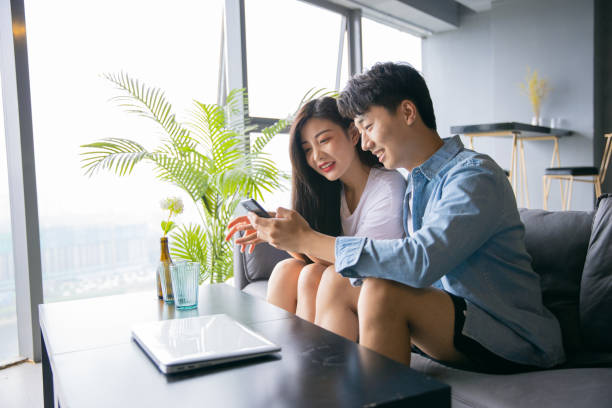 istock Happy young couple share information on mobile phone 1329442778