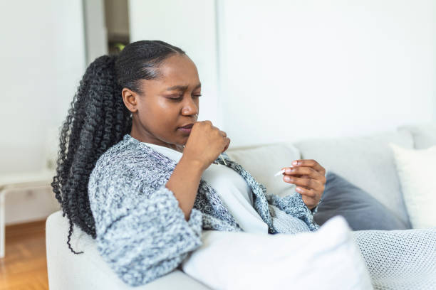 istock African-American woman using cotton swab while doing coronavirus PCR test at home. Woman using coronavirus rapid diagnostic test. Young woman at home using a nasal swab for COVID-19. 1329443578