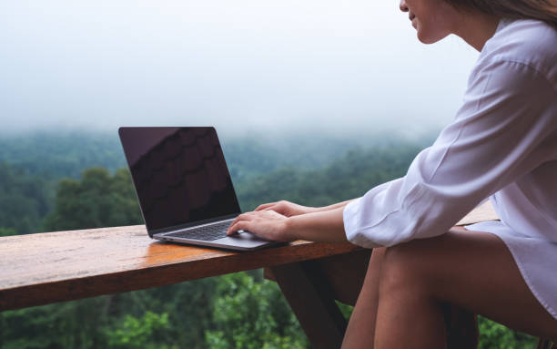 istock a woman using and working on laptop computer while sitting on balcony with a beautiful nature view on foggy day 1329445579