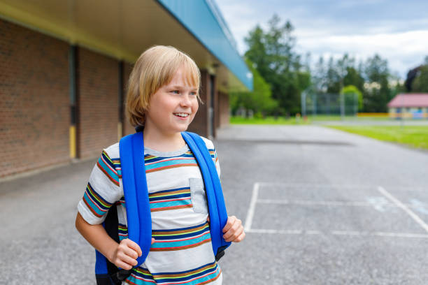 istock Little happy smiling schoolboy walking to school with backpack. Back to school concept. 1329452006