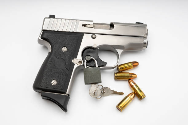 istock Locked disarmed and secured automatic gun on white background , Gun safety concept 1329452711