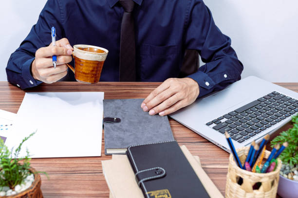 istock business man drinking coffee at his desk 1329455529