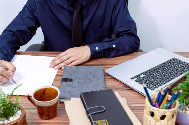istock business man writing a report at his desk 1329455557