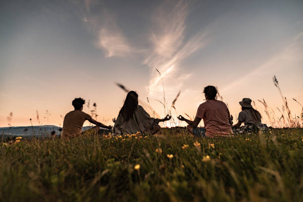istock Back view of relaxed people meditating in nature at sunset. 1329456582
