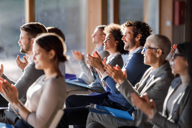 große gruppe glücklicher unternehmer applaudiert auf einem seminar im boardroom. - konferenzzentrum stock-fotos und bilder