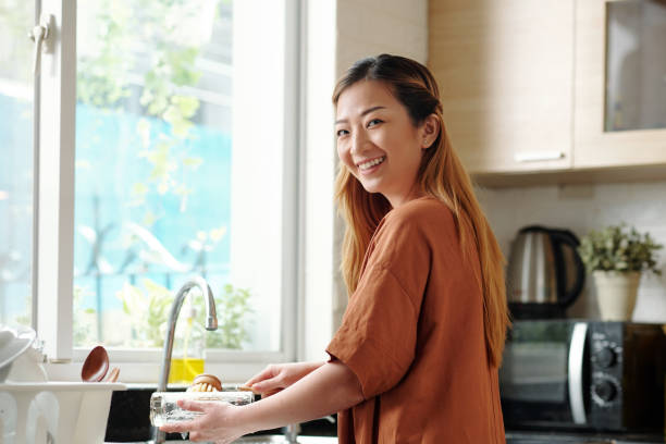 istock Young Woman Washing Dishes 1329459178
