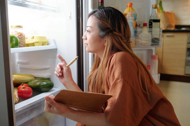 femme vérifiant l’épicerie dans le réfrigérateur - asian cuisine food asian ethnicity vietnamese cuisine photos et images de collection