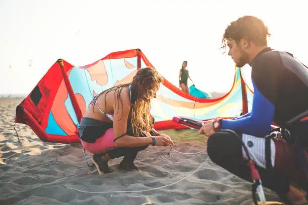 Man and Woman kite-surfers preparing gear