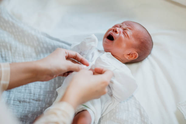 istock Mother changing clothes for her newborn baby 1329463323