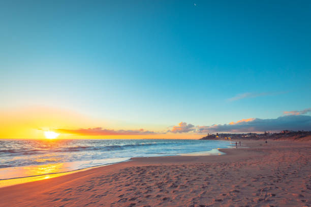 istock Dramatic sunset with people fishing from the beach 1329463596