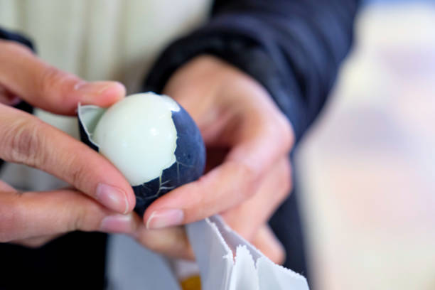 istock Egg Black , people hold boiled black egg with two hands and peel , Black egg food from hot springs Owakudani, Hakone, in Japan. 1329466663
