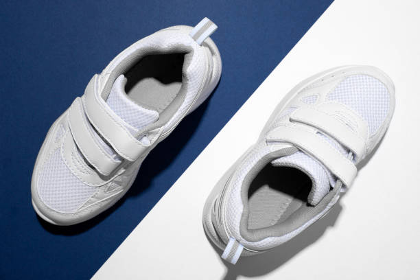 istock top view macro two white unisex sneakers with the front parts pointing in different directions on a blue and white paper background with hard summer shadows 1329466756