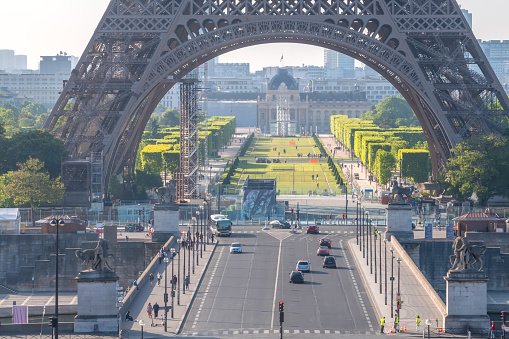 France, Paris - May 26, 2019: Eiffel Tower and Champ de Mars. Few tourists and cars on the Jena bridge on a sunny summer morning