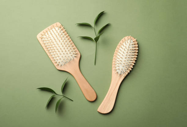 istock Bamboo hairbrushes on green background, flat lay. Conscious consumption 1329467170