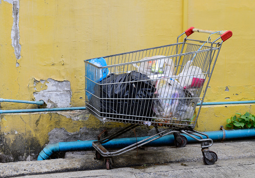 Shopping cart full of garbage bags on the streets.