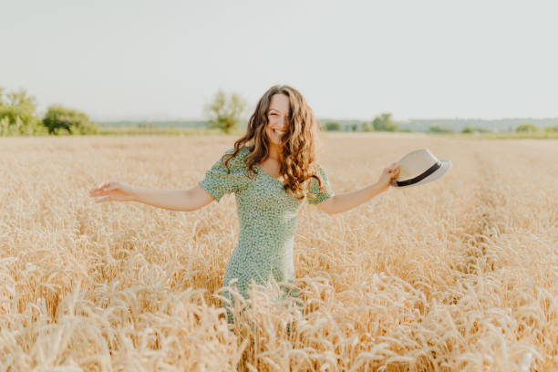 istock Young pretty woman walks in the cornfield while enjoying summer 1329468049