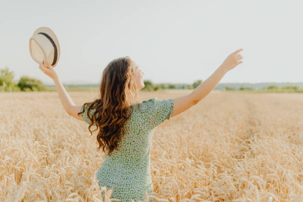 istock Young pretty woman walks in the cornfield while enjoying summer 1329468120