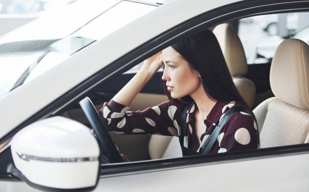 istock Side view of beautiful young brunette that inside of modern automobile. Riding car 1329468356