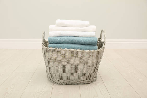istock Wicker basket with folded towels on floor in room 1329469670