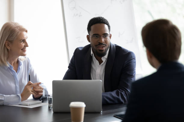 istock Confident mentor giving lecture to interns on corporate meeting 1329476155