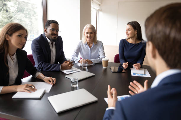 istock Mentor, coach talking to employees, giving training, discussing marketing reports 1329476174