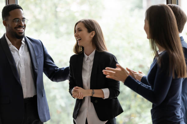 Happy diverse business team applauding coworker success Happy diverse business team applauding coworker success. Employees congratulating promoted colleague, expressing gratitude, recognition, appreciation for good job result, work achieve admiration stock pictures, royalty-free photos & images