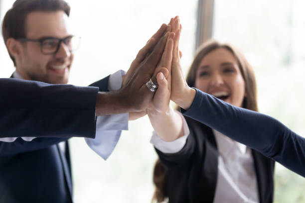 istock Excited office employees giving group high five 1329476191