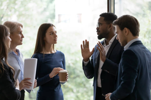 istock Diverse business team standing, talking at office window 1329476208