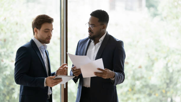 istock Two diverse millennial businessmen, coworkers using tablet 1329476211