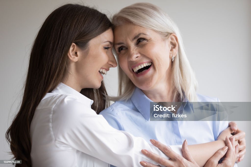 Happy excited senior mom and grownup daughter having fun together Happy excited senior mom and grownup daughter having fun together. Young granddaughter laughing, hugging, talking to elder grandmother. Female family generation, mothers day concept Family Stock Photo