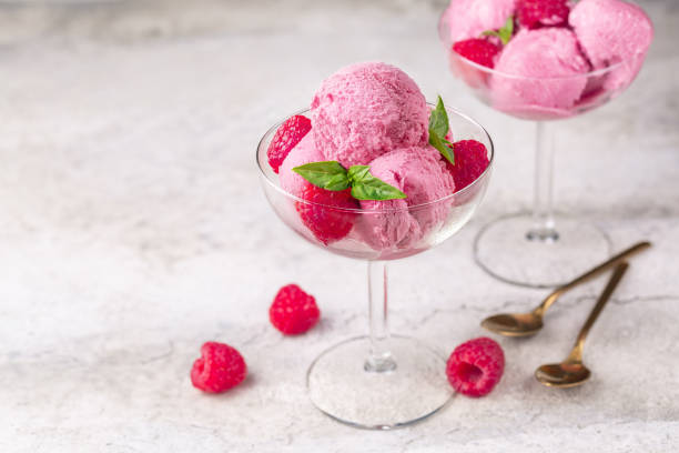 istock Raspberry ice cream with fresh raspberries in a glass bowl on a stone surface. Two portions. Close-up, selective focus. Copy space. 1329480597