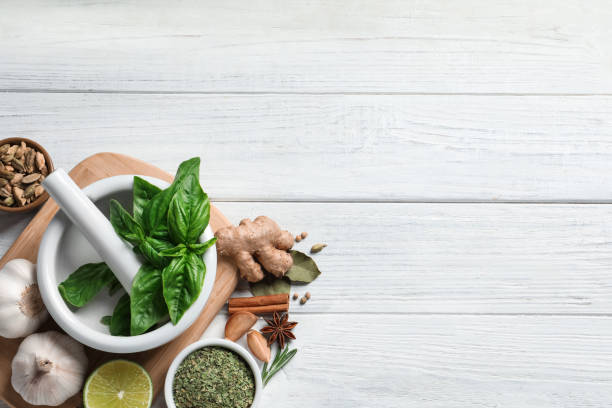 flat lay composition with different natural spices and herbs on white wooden table, space for text - cardamom cinnamon mortar and pestle herb imagens e fotografias de stock