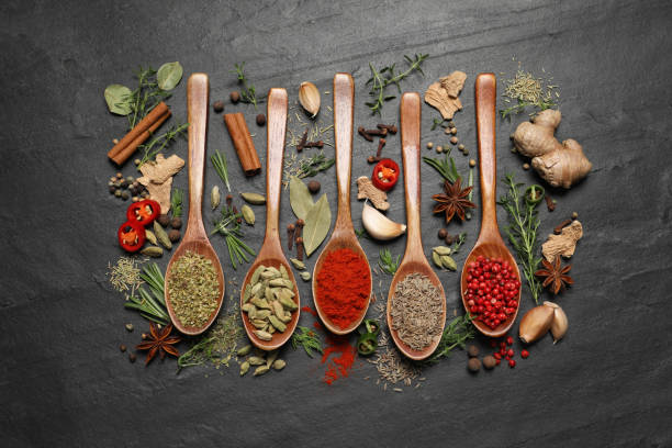 istock Flat lay composition with different natural spices and herbs on black table 1329481454