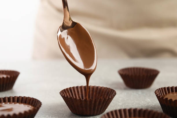 istock Professional confectioner making delicious chocolate candies at grey table, closeup 1329482122