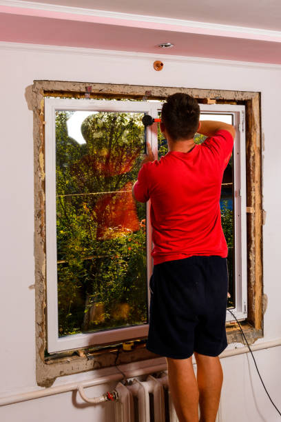 istock the man assembles the window, installs the double-glazed windows and fastens the corner posts with a rubber hammer to hold the glass. 1329482714