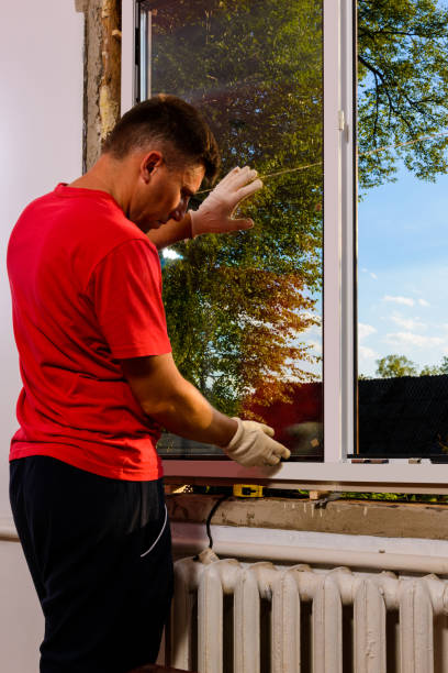 istock The worker inserts glass into the window frame, triple glazing of the plastic window, insulation and insulation. 1329484274