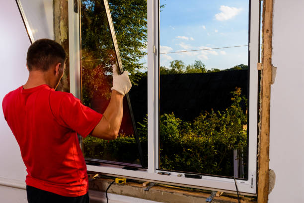 il lavoratore inserisce il vetro nel telaio della finestra, la triplice vetratura della finestra di plastica, l'isolamento e l'isolamento. - installing window glazier glass foto e immagini stock