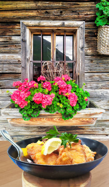 cibo tradizionale austriaco (wiener schnitzel) contro il cottage tradizionale a kaprun, austria - european alps flower north tirol holiday foto e immagini stock