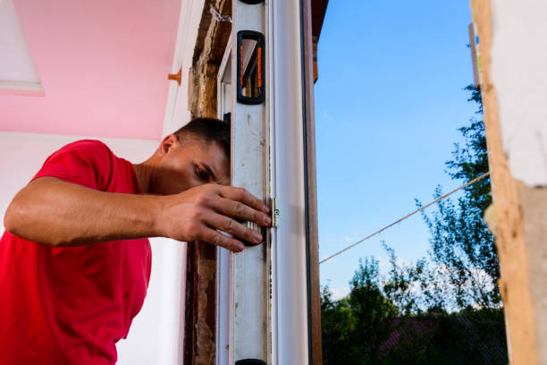 istock The locksmith-installer after fixing the window checks whether it is fixed to the wall, the installation of the window, the master uses the level. 1329486606