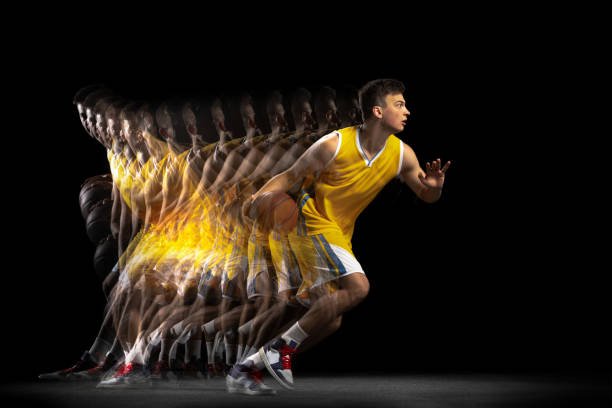 Professional basketball player playing basketball isolated on dark background with stroboscope effect. Concept of professional sport, hobby. In action, motion. Young basketball player training with ball isolated on dark background with stroboscope effect. Concept of professional sport, hobby. Energetical and dynamic. temporal aliasing stock pictures, royalty-free photos & images